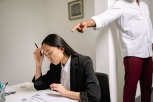 Sexual Harassment Awareness Certification - An office scenario depicting a young woman experiencing bullying from a coworker.