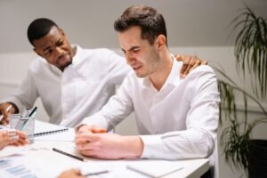 Managing Emotions at Work Certification - Coworkers showing emotional support in a modern office environment.