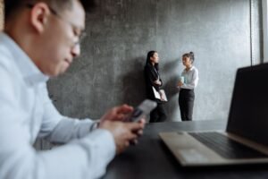 Whistleblowing Training for Employers Certification - Business professionals engaged in a conversation in a contemporary office setting.