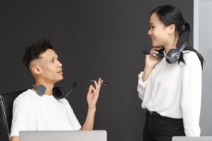 Face to Face Customer Service Certification - Two colleagues with headsets chat in a modern office setting, emphasizing teamwork and communication.