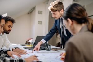 Managing People Certification - A diverse team engaged in a business meeting, fostering collaboration and teamwork in an office setting.