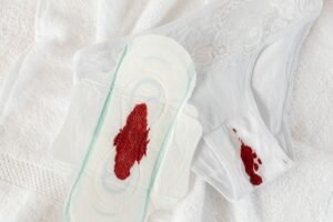 Continence Management and Care Certification - Close-up of a sanitary pad and underwear with menstrual blood stains on a white towel.