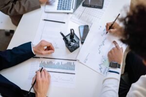 AI for Beginners Certification - Business team analyzing financial charts and graphs during a collaborative meeting.