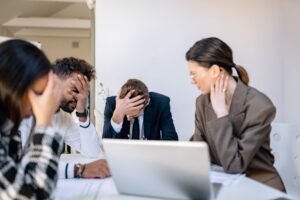 Stress Management (Employees) Certification - A group of stressed business professionals in an office setting, overwhelmed by work.