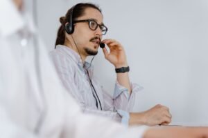 Complaints Handling Certification - Focused customer service agent speaking on a headset in a modern office environment.