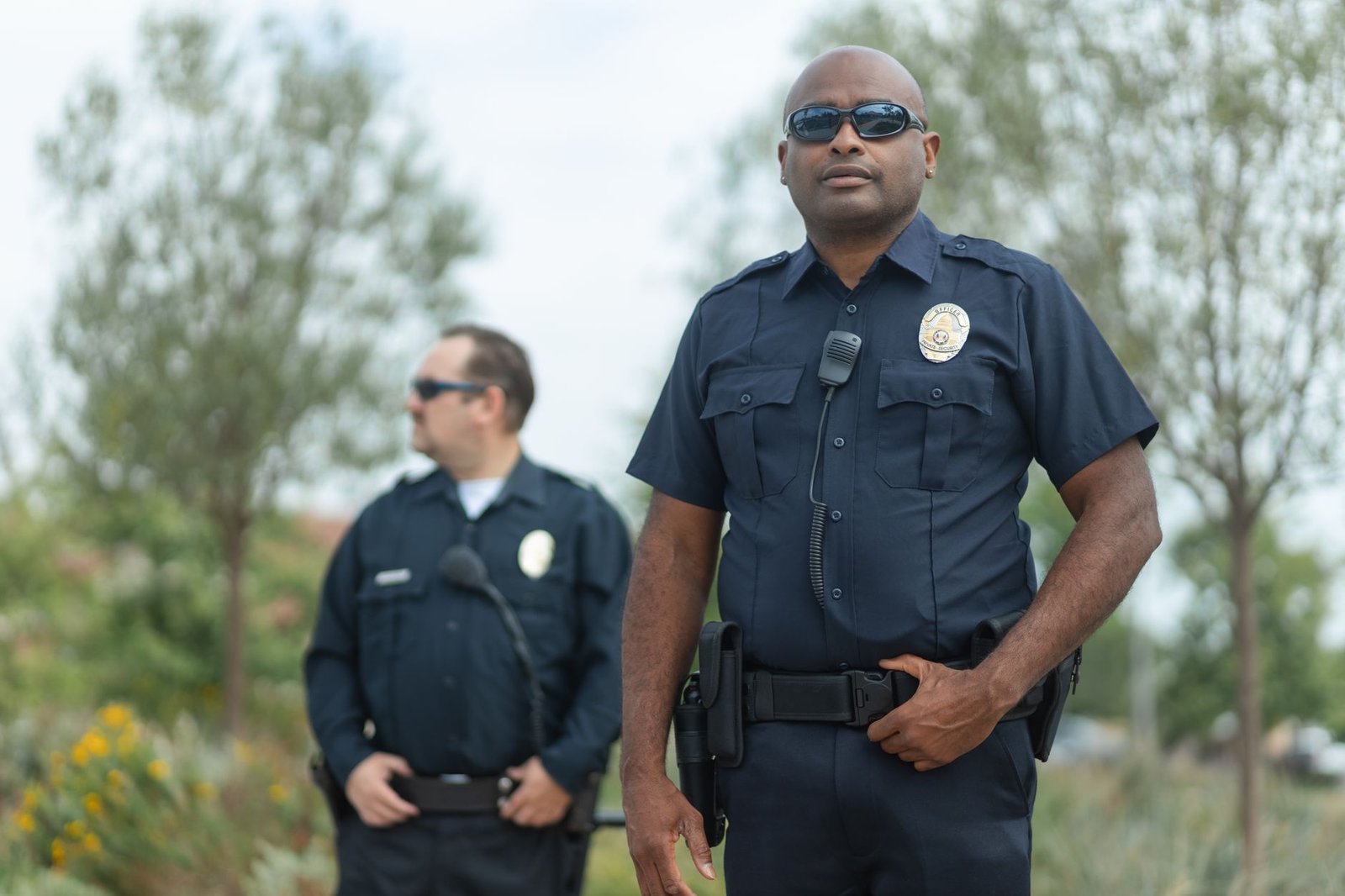 Prevent Duty Certification - Two police officers in uniform ensure public safety, standing confidently outside.