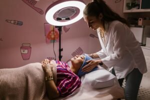 The Self-Care Certification - Woman receiving a relaxing facial treatment at a spa, promoting self-care and relaxation indoors.