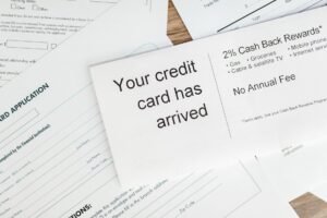 Advance Fee Frauds - Close-up of a letter announcing the arrival of a credit card amidst financial documents.