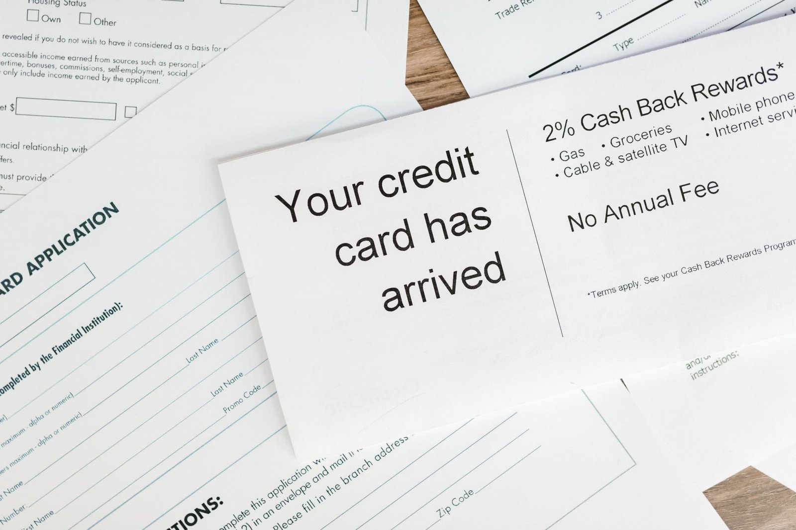 Advance Fee Frauds - Close-up of a letter announcing the arrival of a credit card amidst financial documents.