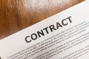Introduction to Employment Law Certification - A detailed close-up of a printed contract document on a wooden table surface.
