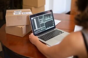 Retail Analytics Certification - Small business owner managing online orders from a laptop in Portugal.