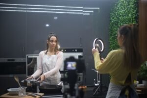 How to Become a Social Media Influencer Certification - Two women creating a cooking video in a stylish kitchen setup with ring light.