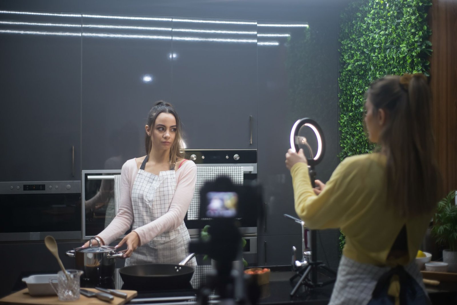 How to Become a Social Media Influencer Certification - Two women creating a cooking video in a stylish kitchen setup with ring light.
