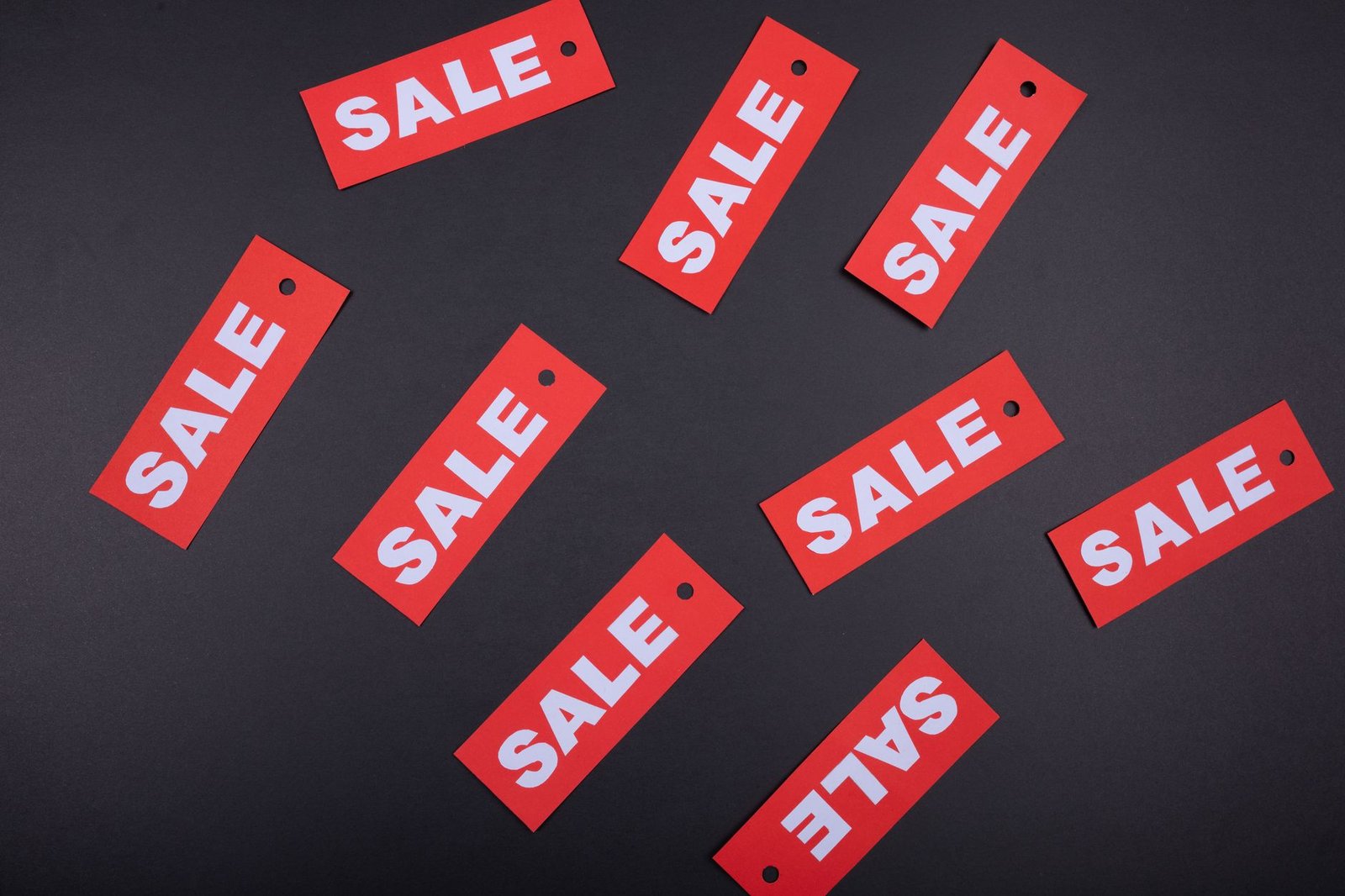 Skills to Succeed at Selling Certification - Top view of red sale tags on a black surface, perfect for marketing promotions.