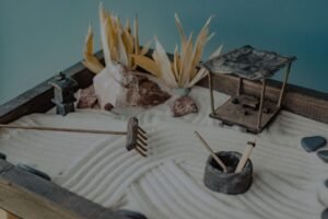 Zen Gardening Certification - A calming miniature Zen garden featuring sand, stones, and decorative elements like a pavilion and lantern.