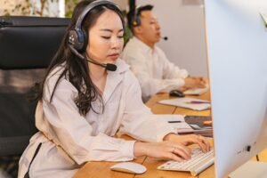 Customer Care Certification - Call center professionals focused on tasks with headsets in a modern office setting.