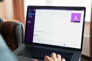 Microsoft Teams Certification - Person using a laptop with an online communication platform, showcasing modern work tech.