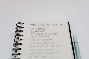 ADHD Awareness Certification - A notebook with handwritten ADHD symptoms like impatience and focus issues.