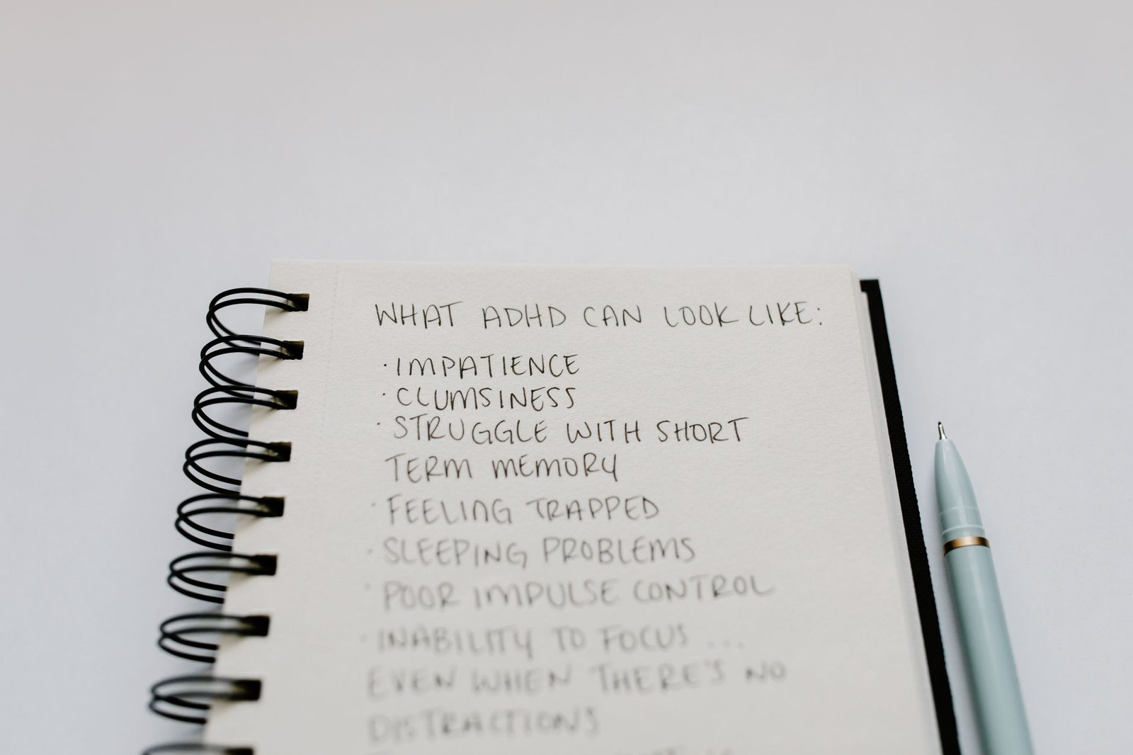 ADHD Awareness Certification - A notebook with handwritten ADHD symptoms like impatience and focus issues.