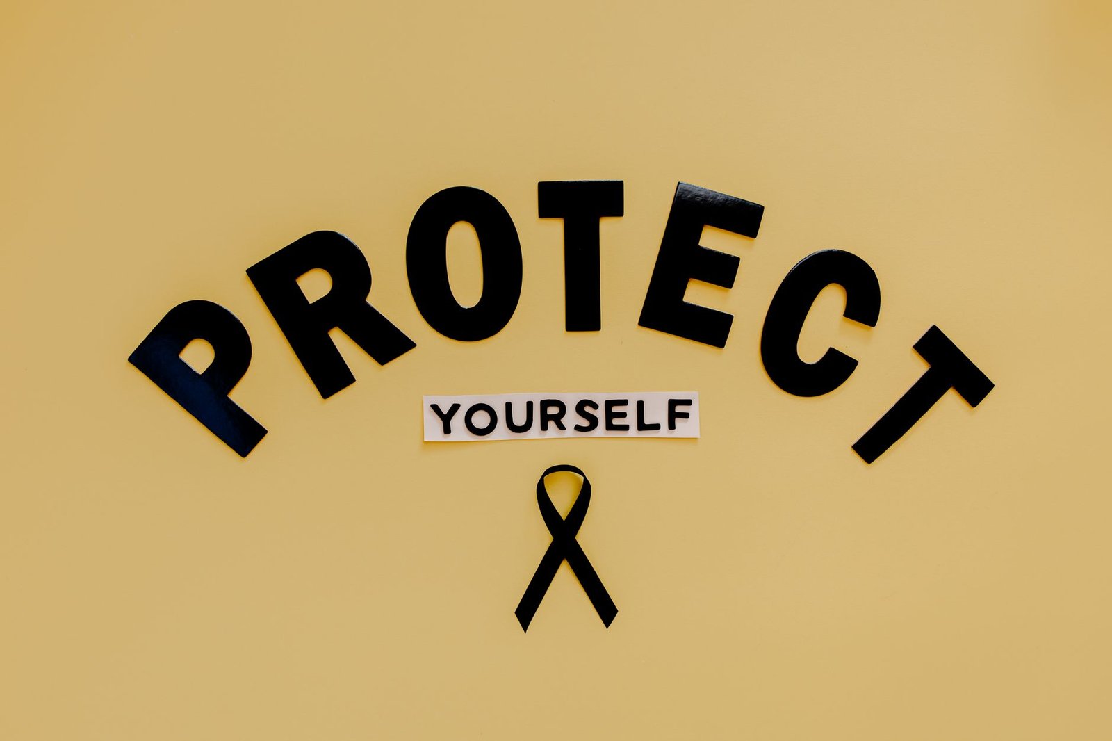 Sexual Harassment Prevention & Reasonable Steps - Conceptual awareness image with "Protect Yourself" text and black ribbon on yellow background.