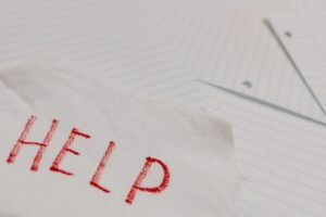 The HMT Sanctions List Certification - A raw and emotional depiction of a plea for help written on torn paper amidst lined sheets.