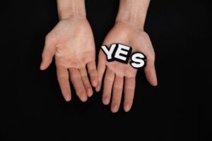 Acceptable Use - Hands presenting the word 'YES' against a black background, symbolizing positivity and agreement.