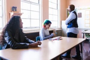 Mental Health Training for Teachers Certification - Teacher and students engaged in a classroom discussion with natural light.