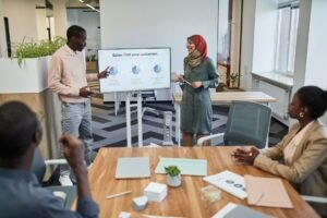 Making Your Sales Pitch Certification - A diverse team engaging in a business meeting focused on sales strategy with visual aids.
