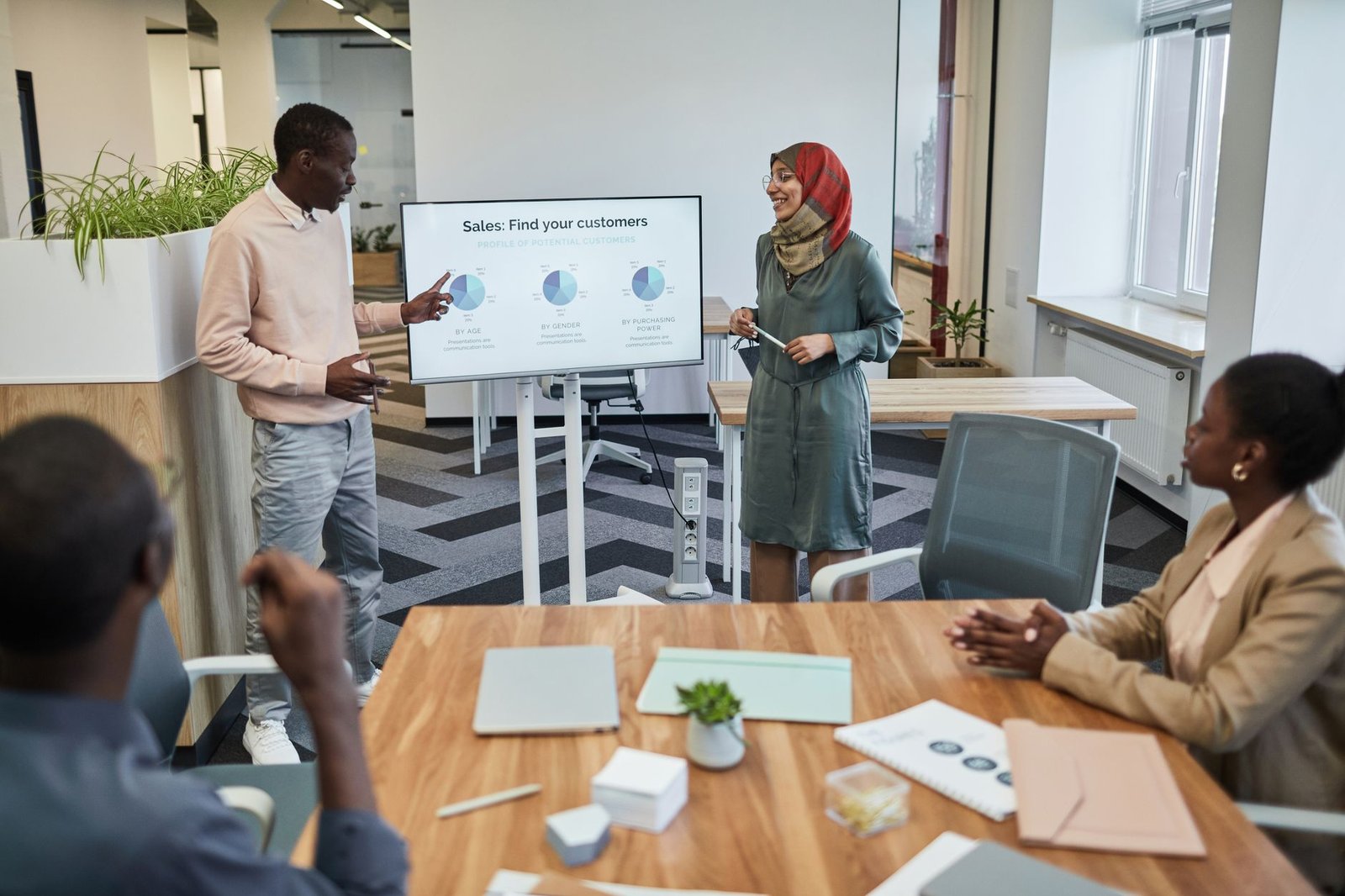 Making Your Sales Pitch Certification - A diverse team engaging in a business meeting focused on sales strategy with visual aids.
