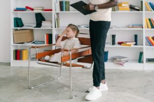 Introduction to Child Counselling Certification - A child in a therapy session with a therapist holding a clipboard.