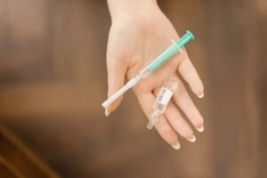 Anaphylaxis Awareness Certification - A close-up of a hand holding a medical syringe and vial, symbolizing healthcare or vaccination.