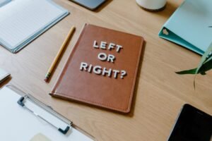 Rational Decision Making Certification - Top-down view of a desk with a notebook asking 'Left or Right?' and various office supplies.