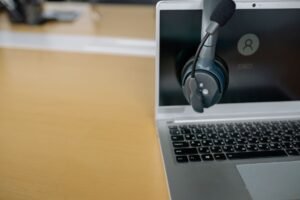 Electronic Customer Service Certification - Close-up of wireless headset on laptop screen, ideal for communication tech visuals.