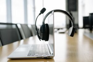 Introduction to VoIP Certification - Sleek laptop with a wireless headset in a bright, modern office setting.