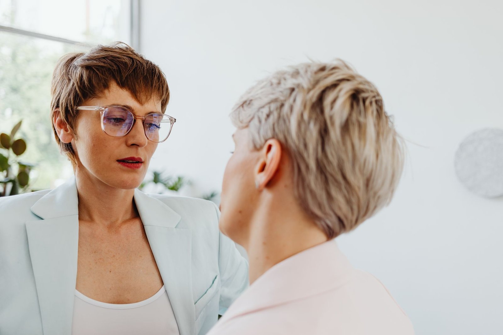 Tackling Sensitive Workplace Conversations Certification - Lesbian couple engaged in a thoughtful indoor conversation, capturing emotion and connection.