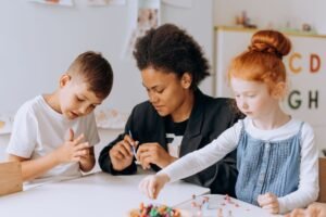 Nursery Assistant Certification - Teacher engaging with children in a classroom setting, fostering learning and creativity.