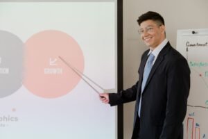 Sales Pitching Certification - Smiling businessman presenting growth strategy in a modern meeting room.