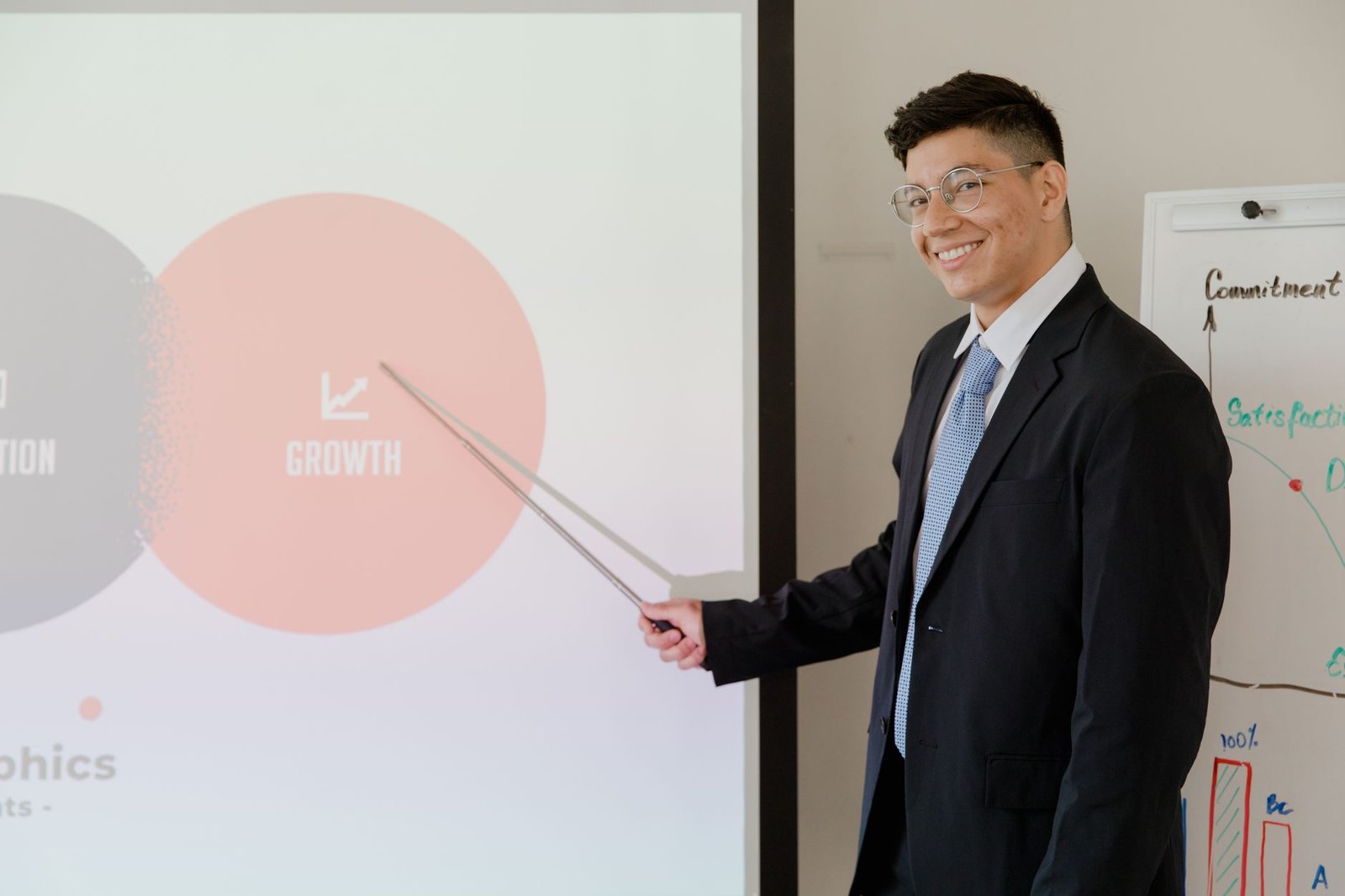 Sales Pitching Certification - Smiling businessman presenting growth strategy in a modern meeting room.