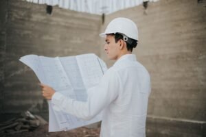 Construction Design and Management Certification - Architect examining blueprints at a construction site in Mexico.