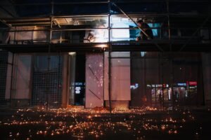 Dangers of Working at Night Certification - Dramatic welding scene on scaffolding at night with sparks flying in an industrial setting.